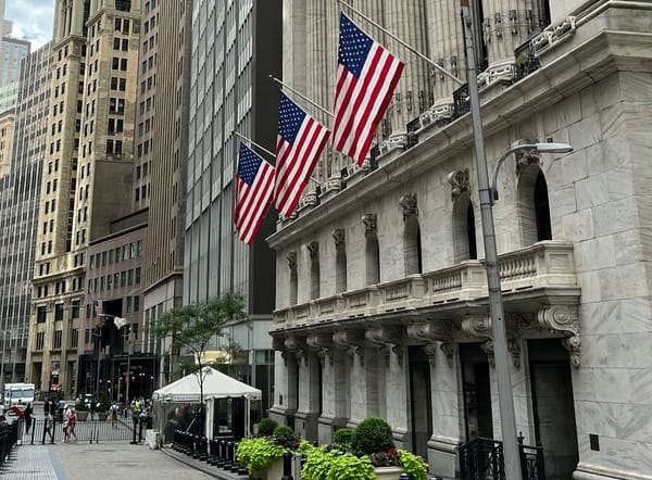 Wall Street financial district with bank buildings and stock market data displayed.