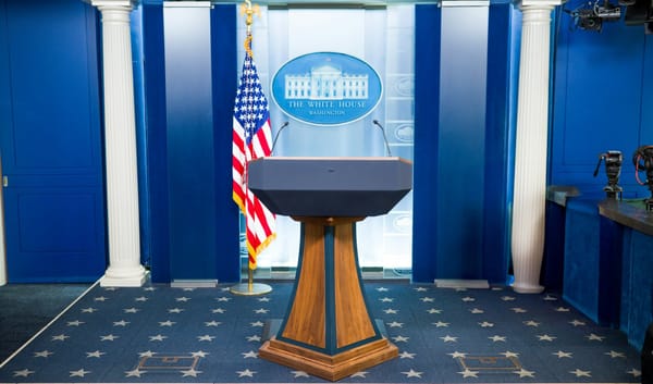 White House empty podium waiting for President Trump to take the stage following the Supreme Court ruling on tariffs, as global trade policy shifts to a 15% universal rate.